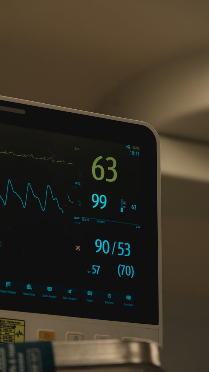 Close-up of a medical monitor showing heart rate and vital signs in a hospital setting.
